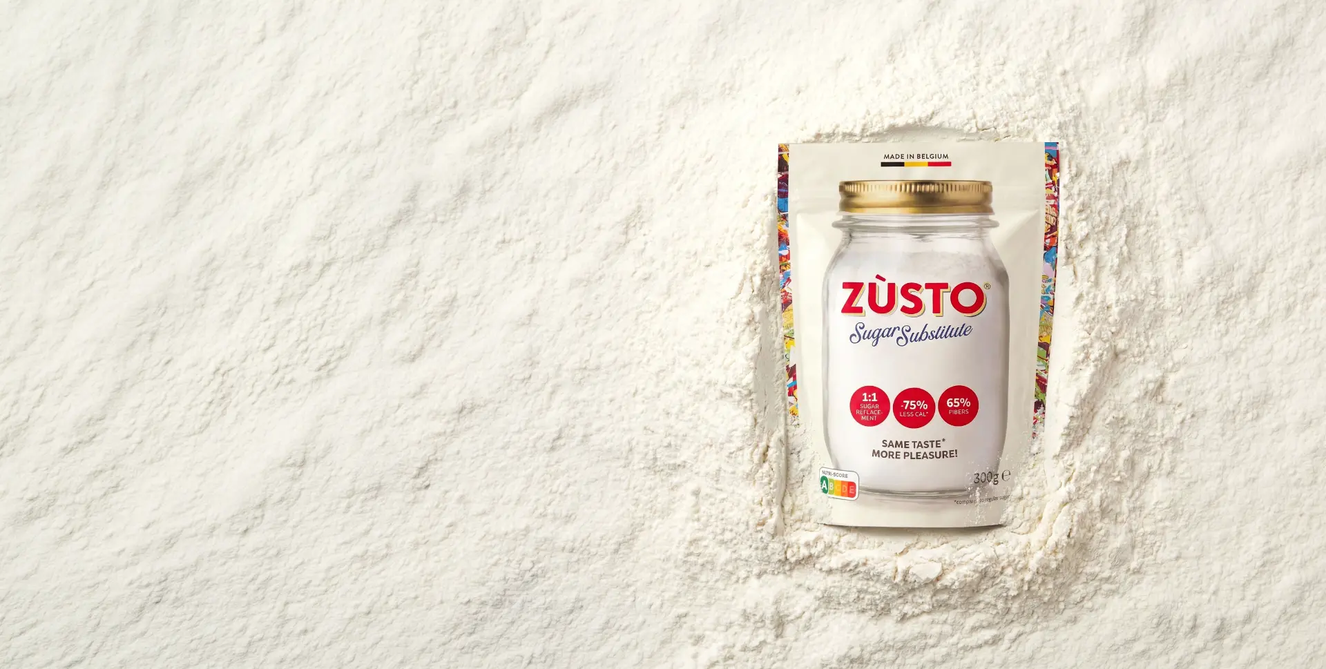 A pack of Zùsto sugar substitute pressed into a bed of fine white Zùsto powder