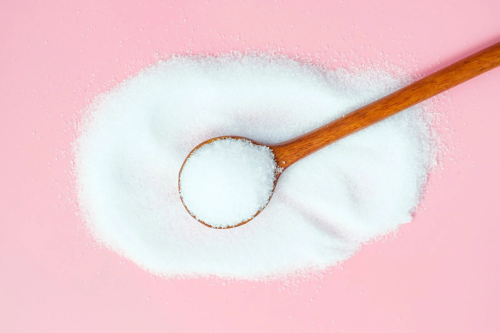 Wooden spoon with isomalt on pink background